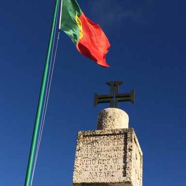 Portuguese flag and metal cross at Nazaré